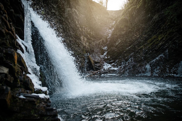 Fuerte cascada de primavera Chernyk en las montañas de los Cárpatos Ucrania Trekking de invierno