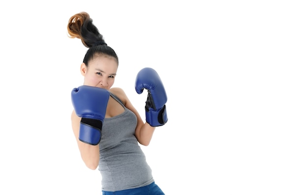 Fuerte, decidida, joven, mujer asiática, en, azul, guantes de boxeo, golpear, y, puñetazos, aire, contra, fondo blanco