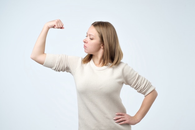 Foto fuerte joven mostrando bíceps siendo seguro de sí mismo