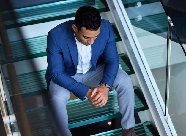 La fuerza no viene de ganar Toma de un joven sentado en las escaleras en el trabajo