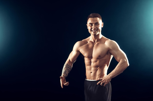 Fuerza de potencia excelente cuerpo culturismo concepto deportivo Joven apuesto hombre en forma muscular que demuestra un cuerpo perfecto
