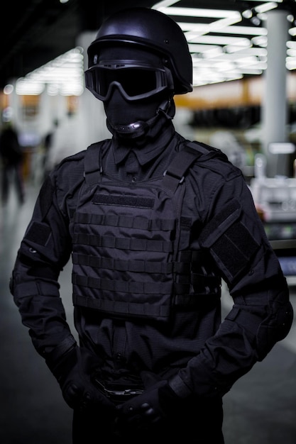 Swat con máscara facial de uniforme negro y chaleco antibalas