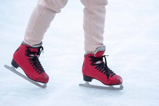 Füße auf Schlittschuhen auf einer Eisbahn. Wintersport und Erholung