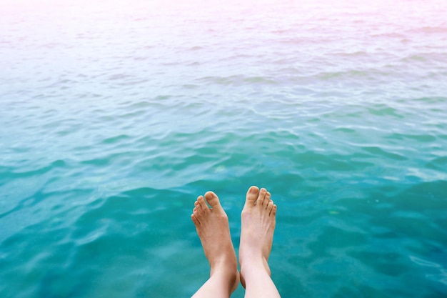 Füße Draufsicht im aquablauen Wasser Hintergrund Frau Körper Beine und barfuß am Sommerstrand