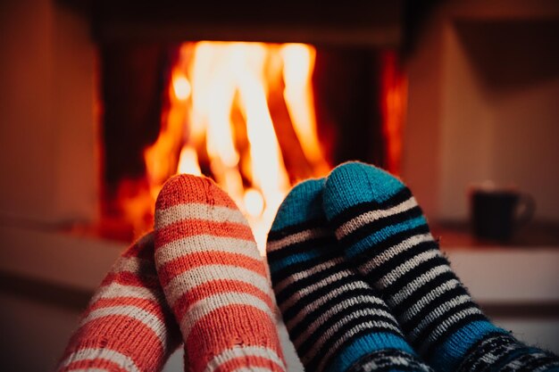 Füße in gestreiften Wollsocken am Kamin Entspannen am Weihnachtskamin am Winterurlaubsabend