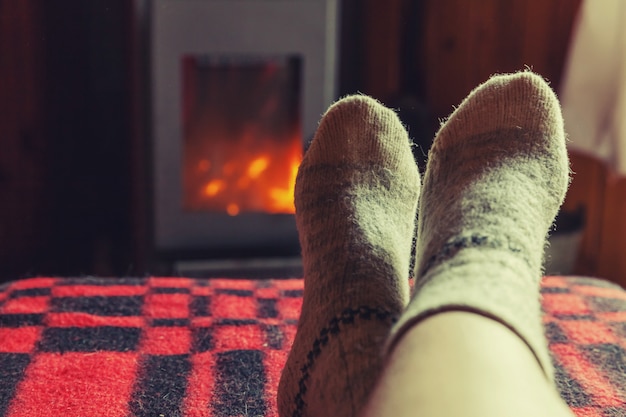 Foto füße in wollsocken am kaminhintergrund