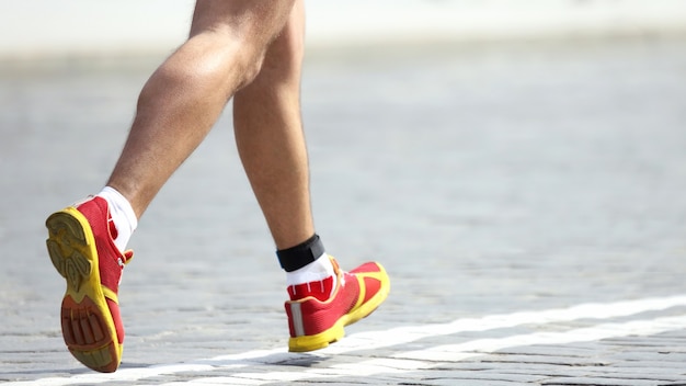 Füße Laufstrecke Athlet auf dem Steinpflaster. Sport und gesunde Lebensweise. Wunsch zu gewinnen. Seien Sie der Erste im Wettbewerb.