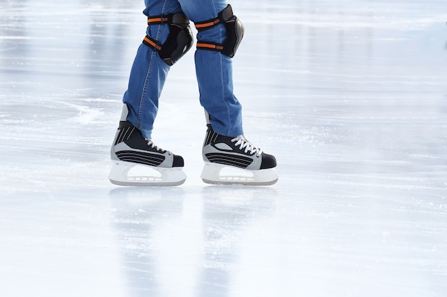Füße rollen auf Schlittschuhmann auf der Eisbahn