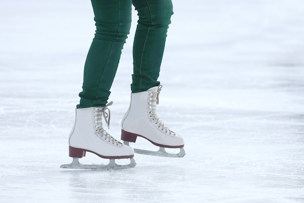 Füße Schlittschuhlaufen auf der Eisbahn. Sport und Unterhaltung. Ruhe und Winterferien.