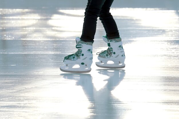 Füße Skaten Mädchen Schlittschuhlaufen auf der Eisbahn. Sport und Unterhaltung. Ruhe und Winterferien.