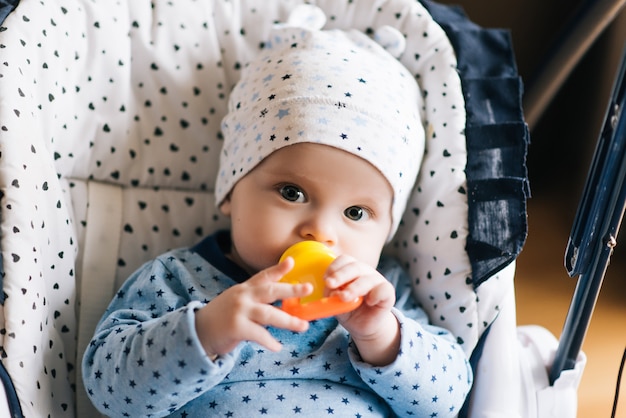 Füttern. Entzückendes Babykind, das im Hochstuhl isst. Baby