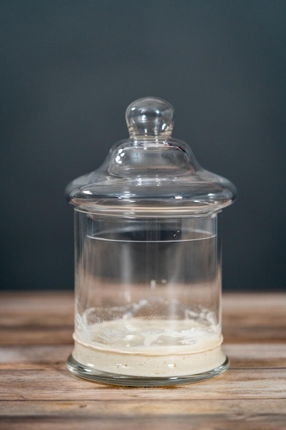 Füttern von Sauerteigstarter in einem Einmachglas aus Glas zum Backen von handwerklichem Brot