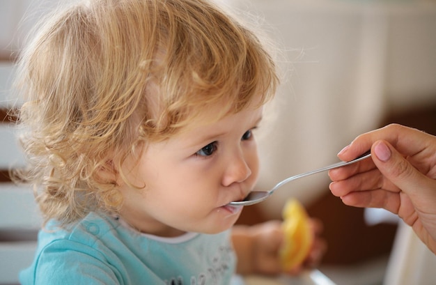 Fütterndes Baby Mutter gibt gesundes Essen an ihr entzückendes Kind zu Hause