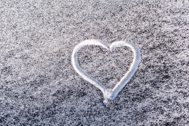 Fuligem preta da sala da caldeira na neve branca Um coração é pintado na ecologia pobre da neve