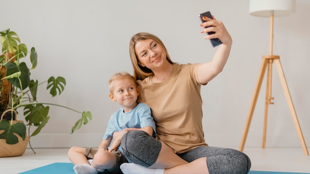 Foto full shot frau und kind nehmen selfie