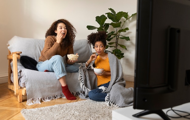 Foto full-shot-frauen, die filme im fernsehen ansehen