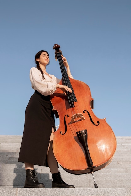 Foto full-shot-musiker, der kontrabass spielt