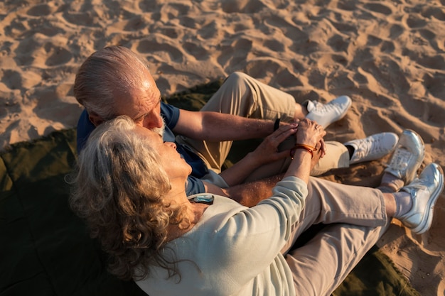 Full-Shot-Paar sitzt am Strand