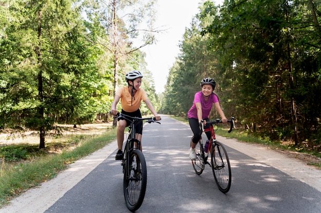 Foto full shot smiley-frauen, die zusammen radfahren