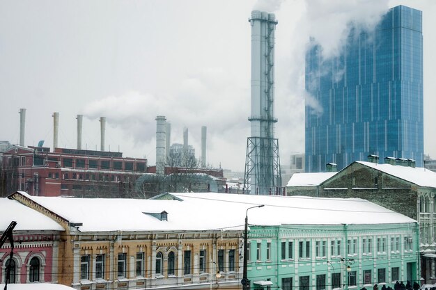 Fumaça das chaminés de uma estação térmica corre para um edifício alto em um dia nublado de inverno