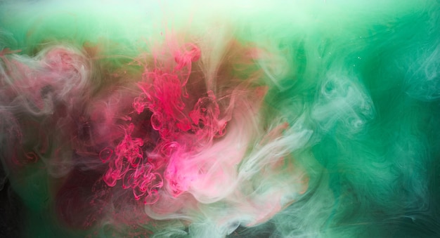 Foto fumaça rosa verde sobre fundo de tinta preta neblina colorida abstrata turbilhão toque oceano oceano pigmento de tinta acrílica debaixo d'água