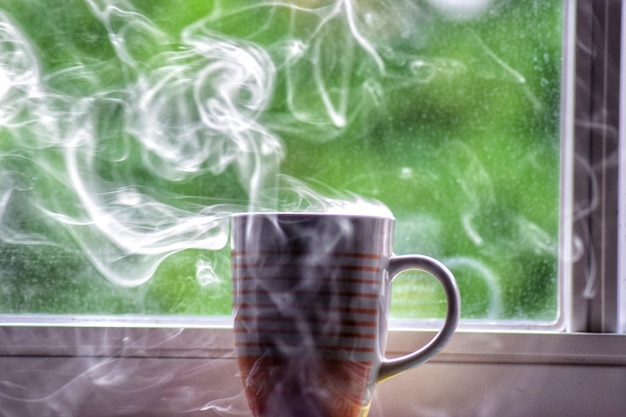 Foto fumaça saindo de uma xícara de café pela janela