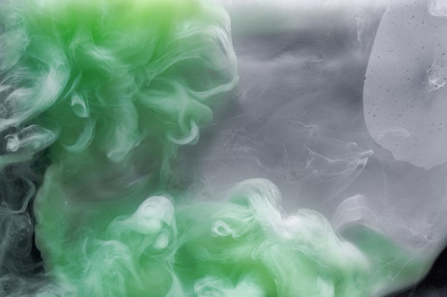 Fumaça verde sobre fundo de tinta preta, névoa colorida, mar abstrato turbulento do oceano esmeralda, pigmento de tinta acrílica subaquático