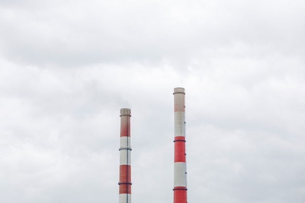 Fumar chimeneas industriales en las nubes. Concepto para la protección del medio ambiente.