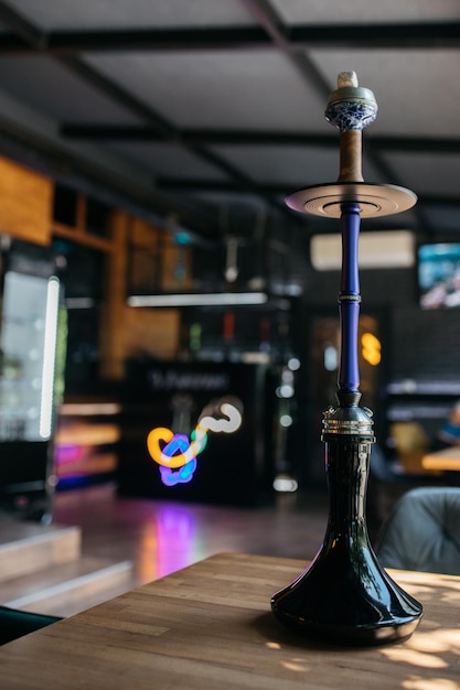 Fumar narguile en un concepto de fiesta La cachimba se encuentra en una mesa de madera en el interior del restaurante Concepto de fumar Chispa de cachimba tradicional Chispas de cachimba Cachimba en la mesa