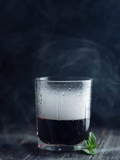 Fume em um copo com álcool vermelho