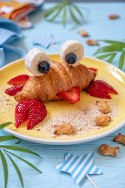 Fun Food für Kinder. Nettes Krabbencroissant mit Obst für Kinderfrühstück