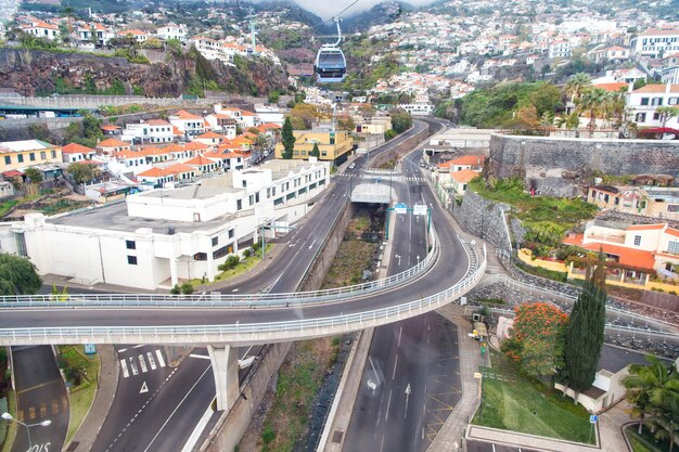 Funchal, Madiera - 27. März 2016: Luftseilbahn oder Seilbahnfahrzeug auf Kabeln und Asphaltstraßen Autobahnen modernes städtisches Verkehrssystem in schöner Stadt auf Bergszene