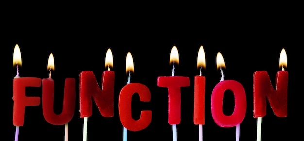 Foto función deletreada en velas rojas de cumpleaños contra un fondo negro