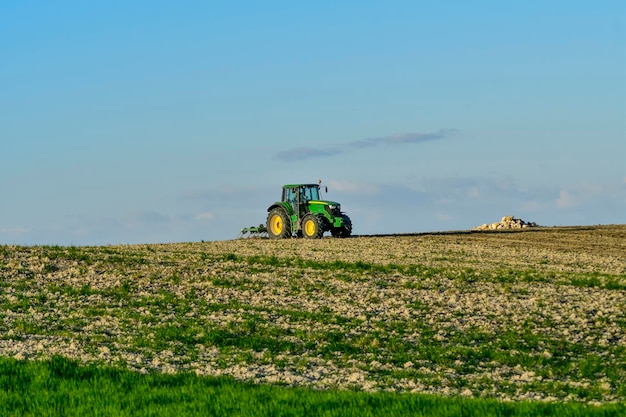 Foto funciona con el tractor fertilizante del campo de cereales.