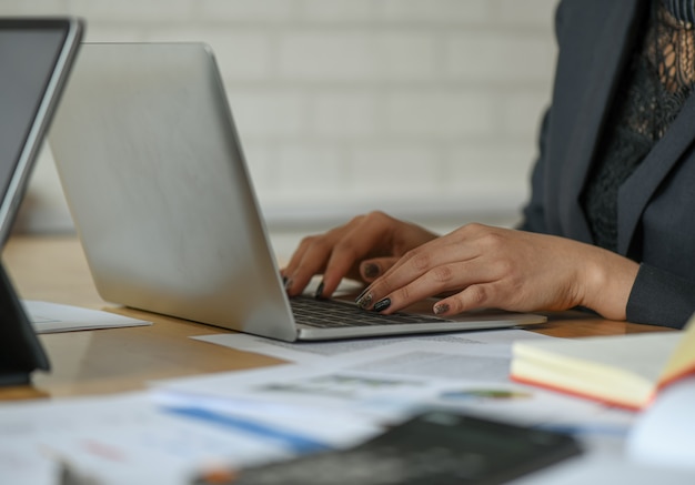 Funcionárias estão usando um laptop na mesa do escritório.