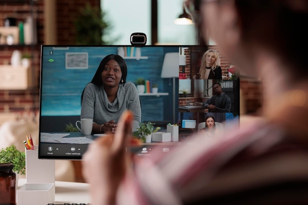 Funcionário conversando em videochamada, freelancer participando de videoconferência em casa, foco na tela do computador. Mulher falando em reunião virtual com colegas, teletrabalho, reunião online