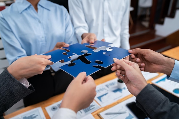 Foto funcionário corporativo colaborar no escritório conectando peças de quebra-cabeça com papel de relatório na mesa como parceria e trabalho em equipe unidade e sinergia no conceito de negócio através da fusão de quebre-cabeças concord