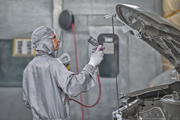 Foto funcionário da oficina de pintura prepara carroceria para pintura.