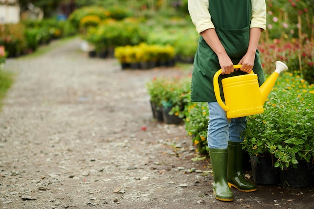 Funcionário de floricultura segurando o regador