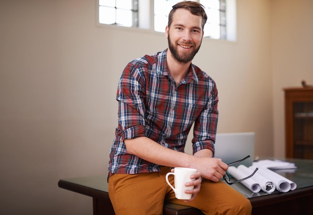 Funcionário de retrato e homem em seu negócio de oficina e plantas com habilidades de idéias e xícara de café Empresário masculino e construtor em seus documentos de escritório e papelada com sucesso de inicialização