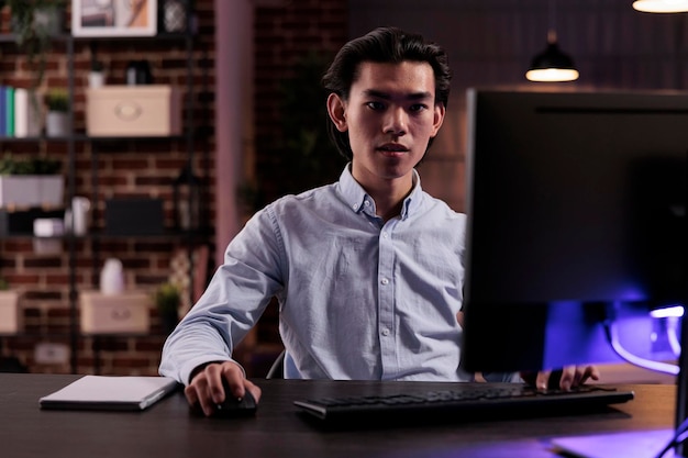 Funcionário do escritório trabalhando em tarefas freelance, criando relatórios de negócios no computador e planejando informações do projeto de pesquisa. Usando o monitor na mesa de casa para planejar a apresentação de gerenciamento da empresa remotamente.