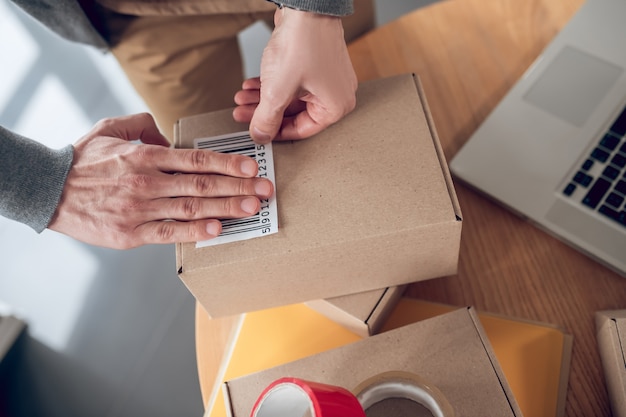 Funcionário experiente preparando mercadorias com código de barras para envio