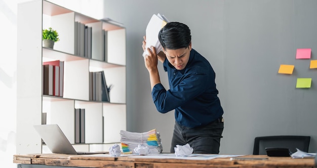 Funcionário louco louco sentado no local de trabalho do escritório com notas adesivas por toda parte, gritando furioso, com raiva, fora do prazo e trabalho estressante no escritório