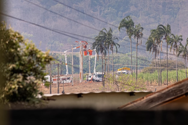 Funcionários da empresa elétrica realizando reparos em postes