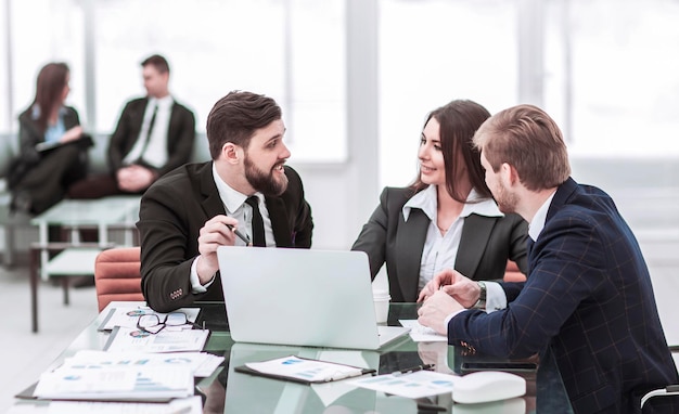 Funcionários da empresa trabalham no laptop com informações sobre o desenvolvimento da empresa