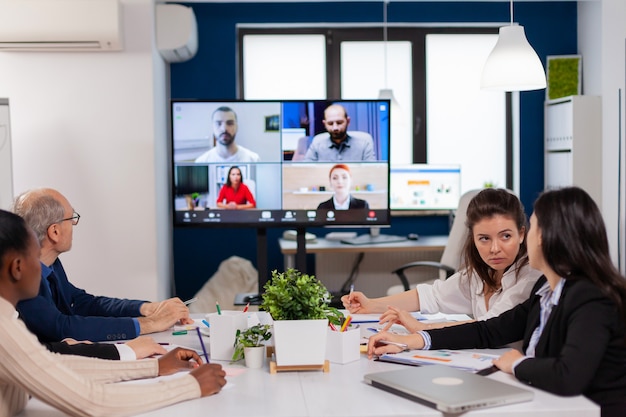 Funcionários de funcionários em conferência em grupo de webcam com colegas de trabalho falando em videochamada