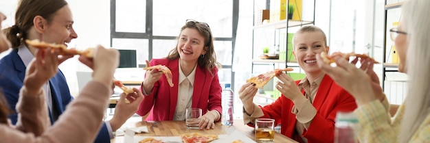 Funcionários felizes da empresa desfrutam de fastfood durante a festa da pizza na comunicação informal do escritório entre