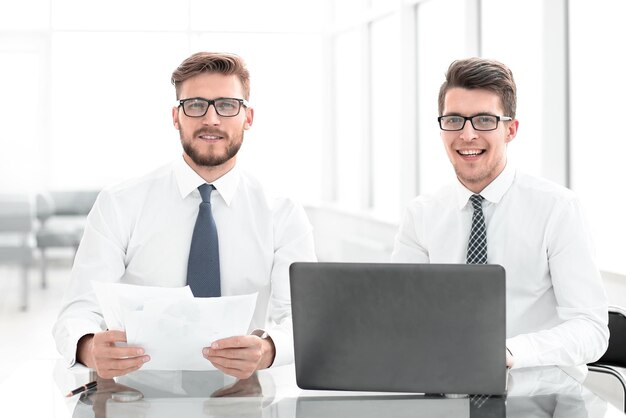 Funcionários felizes sentados em uma mesa em um novo escritório