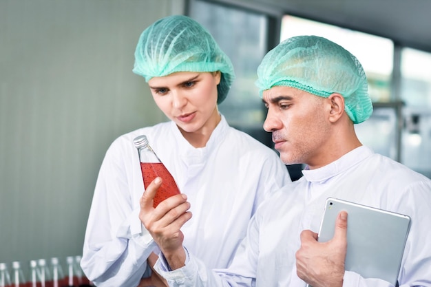 Funcionários trabalham na fábrica de bebidas, equipe inspecionando a qualidade