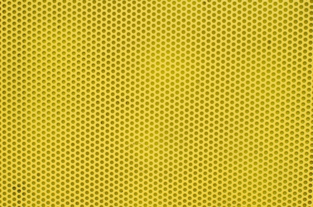 Fundo abstrato amarelo com base de metal, textura da superfície amarela com muitos orifícios redondos.